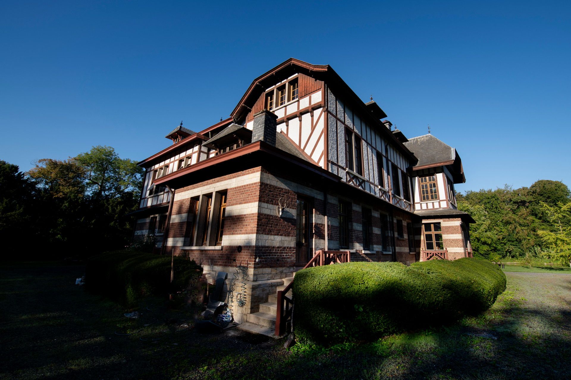 Domaine de la Nèle — the brick-and-timber rear façade under a clear blue sky